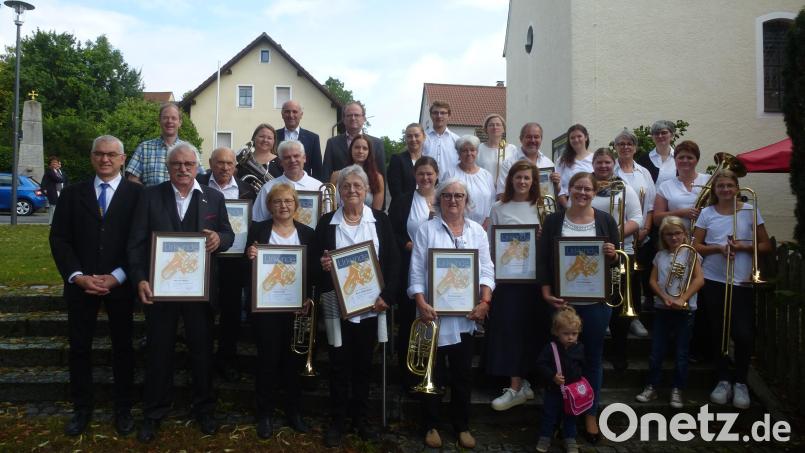 Zehn langjährige Aktive bilden das Fundament des weithin bekannten Posaunenchors Thansüß. Ihnen gratulieren Zweiter Bürgermeister Klaus Siegert, Bezirksobmann Richard Riedel (hintere Reihe, von links), Prädikant Hubert Grill (vorn links) und Pfarrer Matthias Weih (dahinter). Bild: bk