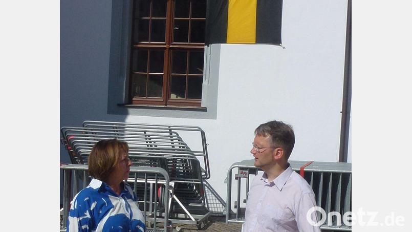 Die Amberger Stadträtin Veronika Niklaus und der Freiberger Stadtrat Jens Grigoleit vor der Stadtfahne Ambergs in Freiberg. Bild: Bild: Niklaus/exb