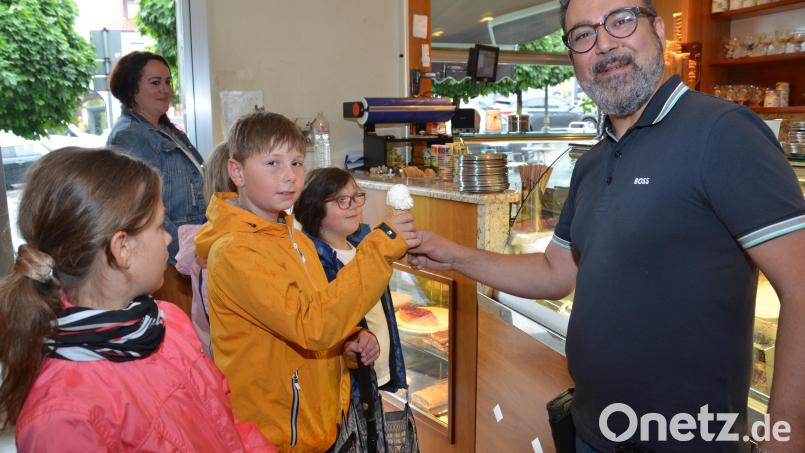 Gelatiere Alessandro Erdas überreicht das Eis an die Hort-Kinder, die den Gutschein von Oberpfalz-Medien als eine der Ersten in Anspruch genommen haben. Bild: dob