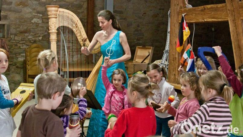 Harfenistin Silke Aichhorn musiziert zusammen mit Kindern. Bild: Wurzer Sommerkonzerte