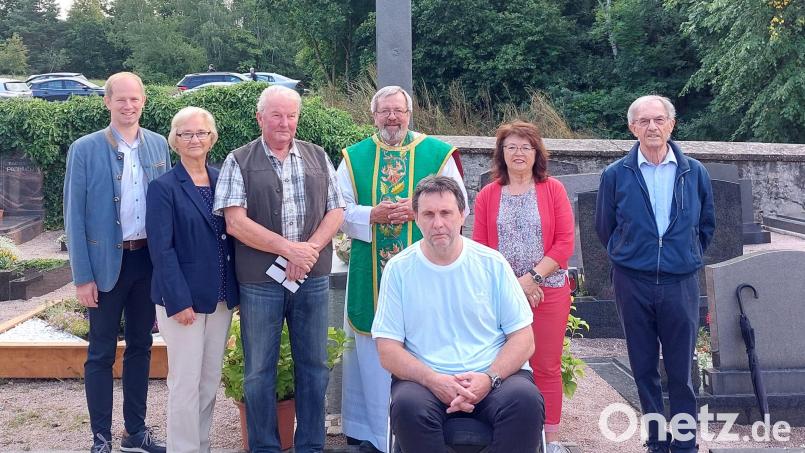 Bürgermeister Konrad Kiener, Elfriede und Erwin Hartinger, Pfarrer Markus Ertl, Reinhold Hauer, Maria Schlögl und Josef Eimer freuen sich über die Restaurierung des Friedhofskreuzes. Bild: Wolfgang Geitner/exb