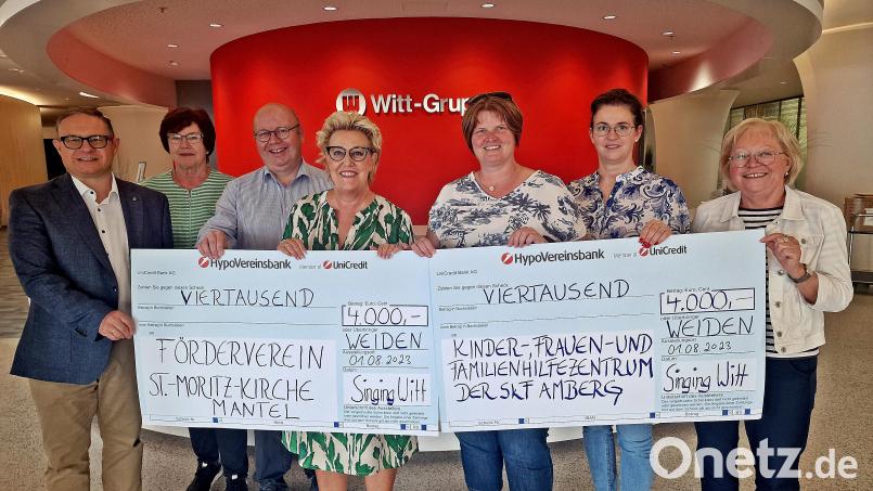 Zwei Organisationen erhalten je 4000 Euro, das Kinder-,Frauen- und Familienhilfezentrum Amberg und der Förderverein der St.-Moritz-Kirche in Mantel. Singing-Witt-Chorleiterin Stefanie-Zühlke-Schmidt (Vierte von links) überreicht den symbolischen Scheck. Bild: R. Kreuzer