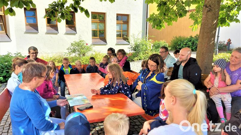 Eine große Kinderschar erlebte mit der Lesepatin Carola Wittek (links) unter dem Kastanienbaum im Rathaushof die Rettung des Regenbogens. Bild: lg