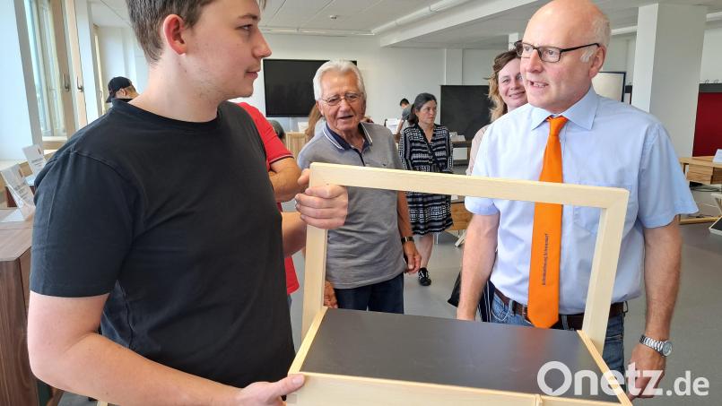Absolvent Philipp Weist aus Wölsendorf (links) im Gespräch mit dem Prüfungsvorsitzenden Heinrich Lippert (rechts). In der Hand hält er seine Arbeitsprobe, eine Multifunktionsablage. Bild: Hirsch/exb