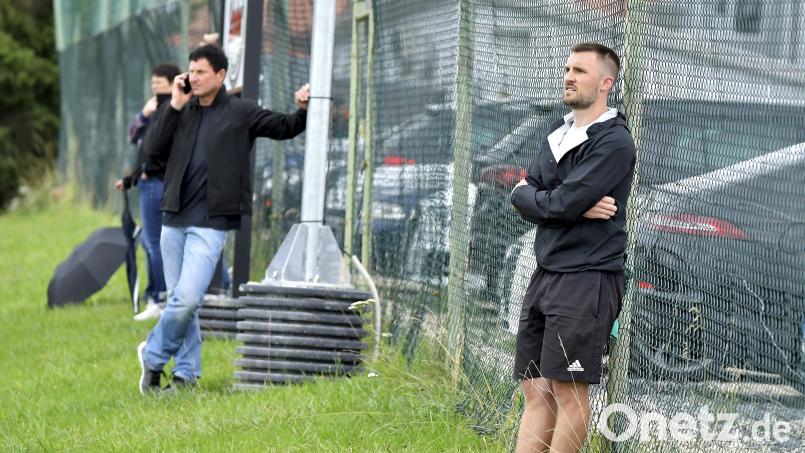 Christoph Hegenbart, der Trainer des 1. FC Schlicht, stand etliche Meter von der Bank seiner Mannschaft entfernt an einem Zaun. Bild: Hubert Ziegler