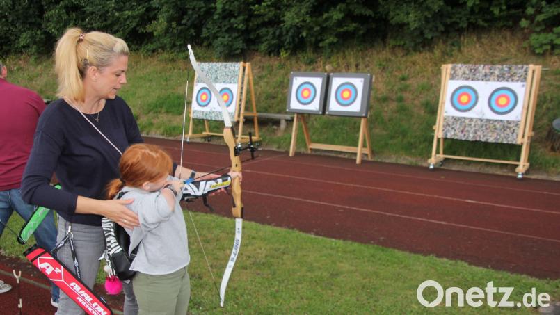 Nicole Beer erklärt einem Mädchen das Bogenschießen. Bild: kro