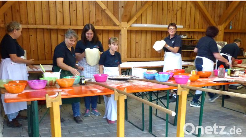 Ein eingespieltes Team bereitete in der Gemeinschaftshalle die Pizzen und den Brotkuchen für den Backofen vor. Bild: no