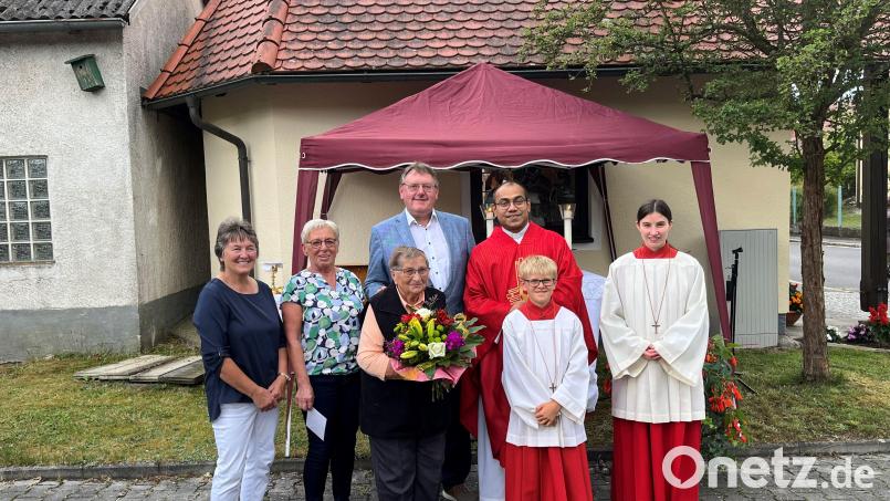 Nach 45 Jahren als Mesnerin wird Christa Schmid (vorn, Mitte) mit einem Geschenk und einem Blumenstrauß von Pater Jimmy (hinten rechts) und Bürgermeister Hans-Martin Schertl (hinten links) geehrt und verabschiedet. Als Mesnerinnen fungieren künftig Rita Schöpf und Irmgard Zeitler (von links). Bild: Stefanie Gradl