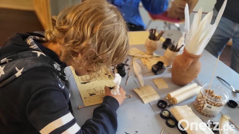 Die Kinder sind in der eingerichteten römischen Schreibstube ganz vertieft in ihre Arbeit. Bild: Carola Reul/exb
