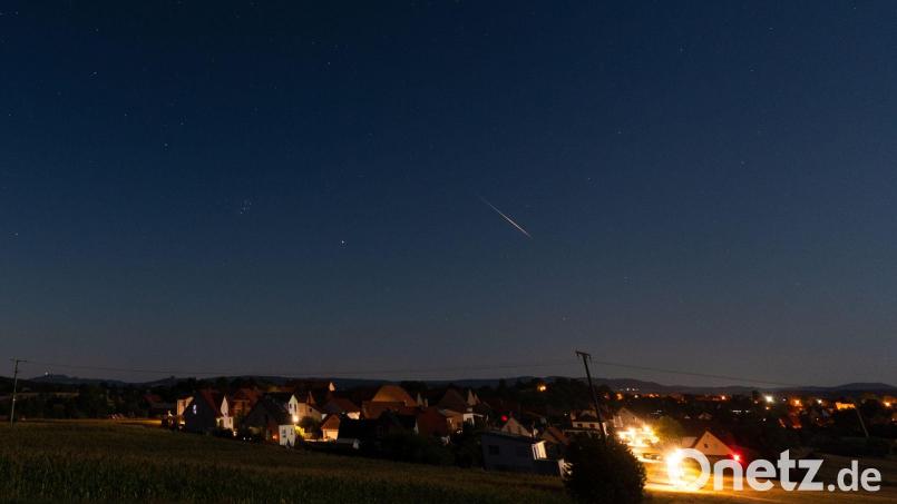 Eine Sternschnuppe verglüht am Nachthimmel über Höfen in Bayern. Bild: Nicolas Armer/dpa