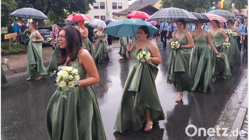 Die Festdamen versuchen, sich vor Regen zu schützen so gut es geht. Bild: jua