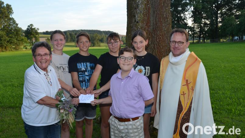 2000 Euro erhalten die Ministranten von Flohmarktsammlerin Christa Wildenauer für die nächste größere Ausflugsfahrt zur Unterstützung. Dekan Alexander Hösl dankt ihr im Namen alle Messdiener. Bild: dob