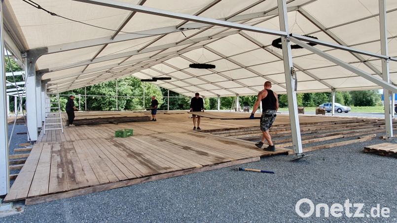 Die Aufbauarbeiten für das Wiesenfest haben begonnen. Auf dem Bild verlegen Arbeiter den Holzboden des Festzeltes. Bild: kaz