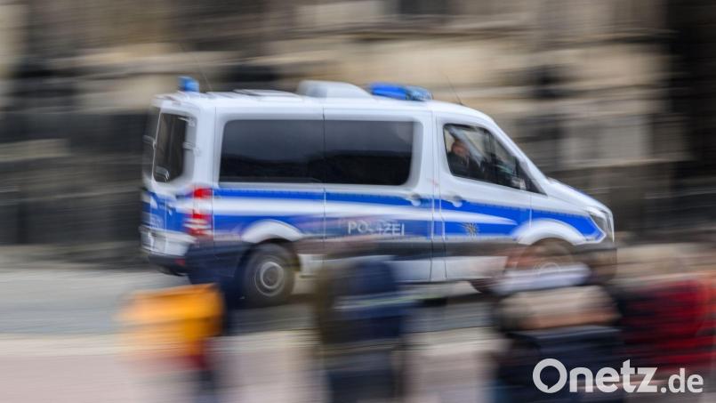 Ein Einsatzwagen der Polizei fährt durch eine Stadt. Bild: Robert Michael/dpa/Symbolbild