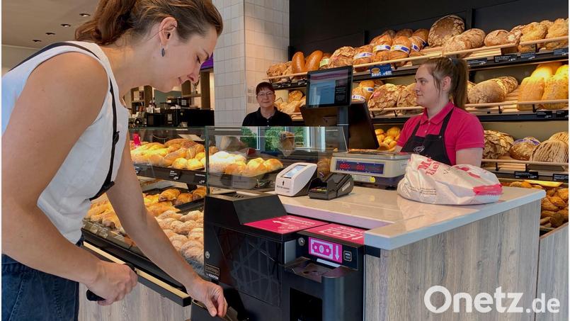 Eine Kundin nimmt sich das Wechselgeld am Münzautomaten in der Filiale von Backhaus Kutzer in Weiden Mooslohe. Bild: Gabi Schönberger