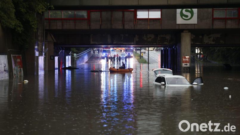 Einsatzkräfte der Feuerwehr können nur noch mit einem Schlauchboot zu den Autos in einer überschwemmten Unterführung gelangen. Bild: Oßwald/News5 /dpa