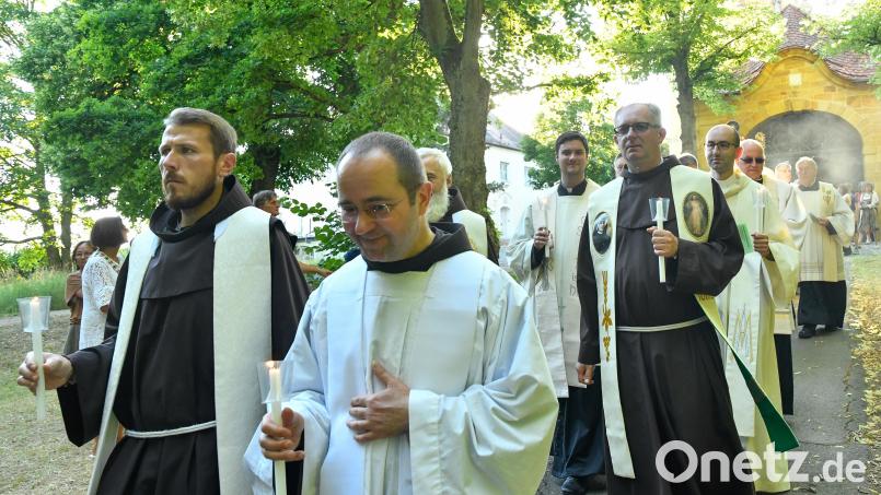 Pater Xaver Skrobis (Zweiter von links) marschiert bergab, allerdings vertrauensvoll mit einer Kerze in seiner Hand und umgeben von vielen Geistlichen (links sein franziskanischer Mitbruder vom Mariahilfberg, Pater Clemens) und Gläubigen, die ihn nicht nur bei der Lichterprozession zum Abschluss des Bergfestes immer gerne sahen. Dennoch muss der Geistliche nun nach neun Jahren das Kloster und Amberg verlassen, weil eine neue Aufgabe als Guardian in Neukirchen beim Hl. Blut auf ihn wartet. Archivbild: Petra Hartl