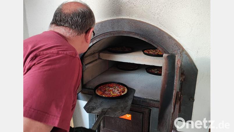 Roland Sandmann holt gerade eine frisch gebackenen Pizza aus dem vereinseigenen Ofen. Bild: M. Blumenthal/exb