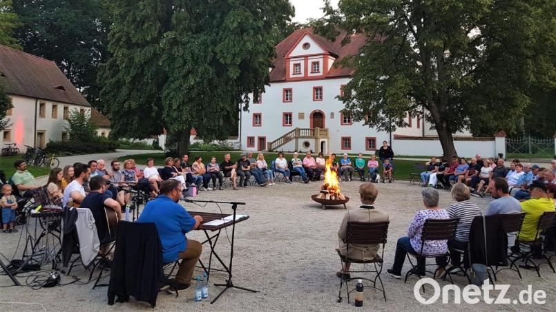 Bürgermeister Hans Walter (Vorne am Mikrofon) erzählte im Schlosshof Wolframshof Lagerfeuergeschichten und regionale Sagen. Bild: VG Kemnath/exb