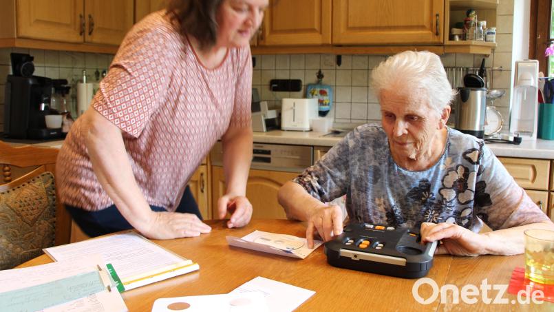 Ruth Nolte (links) erklärt Krista Hehberger, wie sie mit einem Gerät Hörbücher abspielen kann. Bild: Anna-Lena Weber