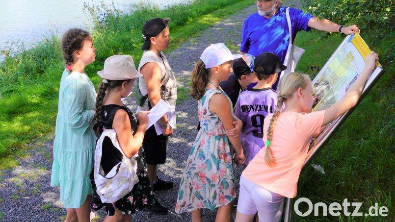 Josef Forster erklärt den interessierten Ferienkindern die Geschichtstafeln. Dabei lösen die Mädchen und Jungen ein Geschichtsweg-Quiz. Bild: fvo