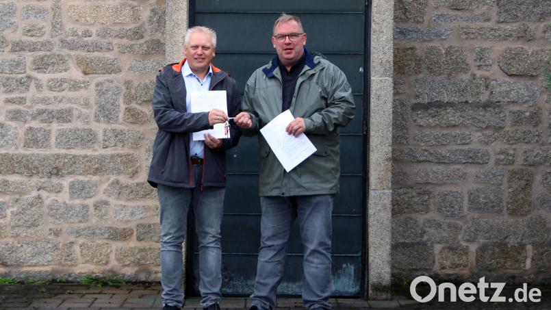 Evangelischer Pfarrer Thomas Berthold (rechts) übergibt den Schlüssel der entwidmeten evangelischen Kirche an Bürgermeister Jürgen Kürzinger. Bild: lep
