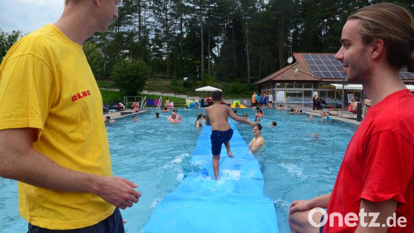 Die DLRG hilft bei der Neptun-Party kräftig mit. Einmal &quot;übers Wasser zu laufen&quot; ist für die Kinder ein besonderer Spaß. Bild: Kunz