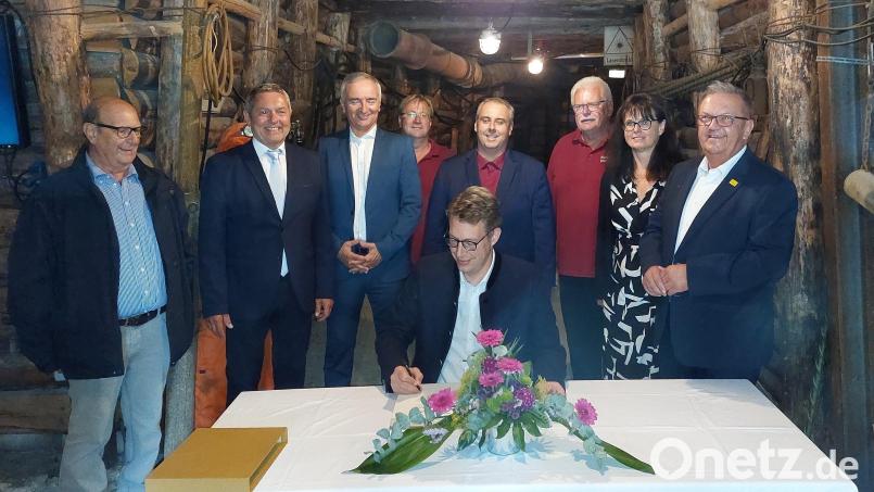 Im Schaustollen auf Maffei trägt sich Staatsminister Markus Blume (sitzend) ins Goldene Buch der Stadt Auerbach ein. Bild: mfh