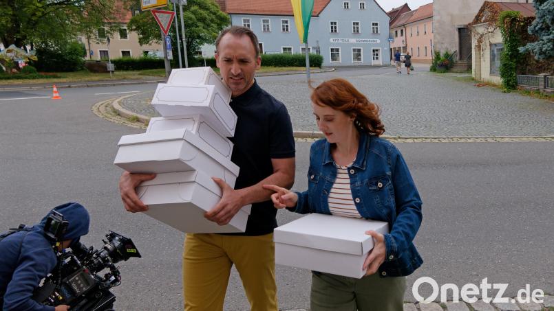 Drehstart Montag, 8.15 Uhr, Klappe 1: Die Schauspielerin und Produzentin Christina Baumer in der Hauptrolle als Magdalena Brandt und Schauspieler Jürgen Fischer als Sepp Hofmann tragen Kuchenschachteln über den Deschplatz in Tirschenreuth. Bild: Norbert Grüner/Set- und Standbildfotograf Stonewoold Film e. V.