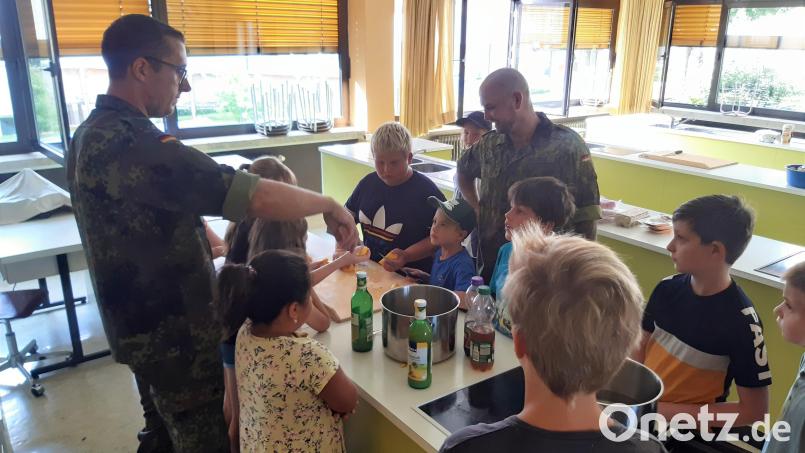Die Kinder beobachten gnenau, wie man Burger, Nuggets &amp; Pommes, Eistee oder auch Limonade selbst herstellen kann. Bild: Johannes Sperr/exb