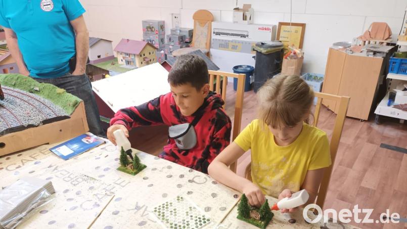 Leonhard und Miriam sind beim Ferienprogramm der Interessengemeinschaft Modellbahnfreunde konzentriert bei der Sache. Das ferngesteuerte Lenken von Fahrzeugen und das Bauen von Dioramen im Maßstab 1 zu 32 macht den Kindern viel Freude. Bild: Helmut Rothmeier/exb