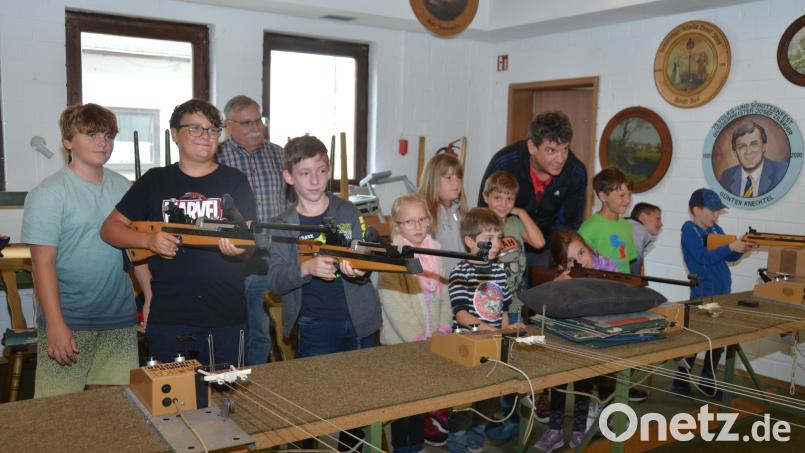 Kinder unterschiedlicher Altersstufen dürfen sich im Schützenhaus entweder an der Lichtpistole oder am Luftgewehr ausprobieren. Schützenmeister Robert Diermeier (rechts) und der ehemalige Schützenmeister Anton Hufnagl (hinten) geben Tipps. Bild: dob