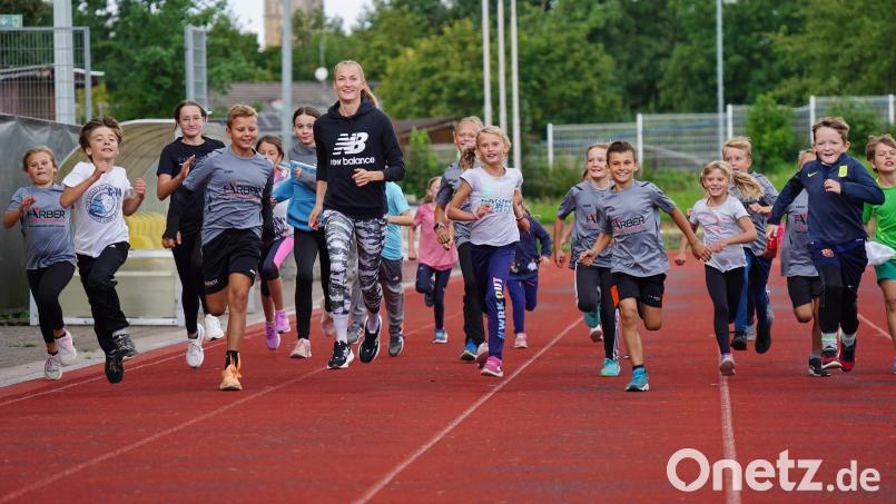 Corinna Schwab lief mit den Kindern der Leichtathletik-Olympiade des TV 1861 Amberg eine kleine Runde im Stadion am Schanzl. Bild: ref