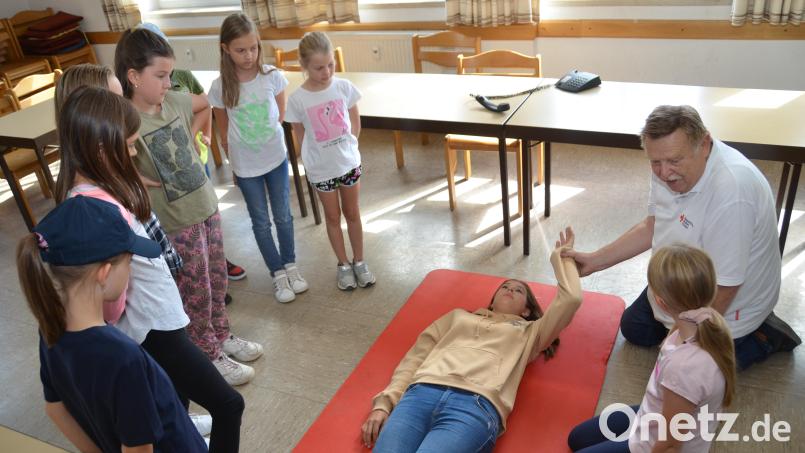 Stellvertretender Bereitschaftsleiter Josef Solfrank machte die Teilnehmer des Kinderferienprogramms mit seiner Enkelin Lena (liegend) fit als Juniorhelfer. Bild: dob