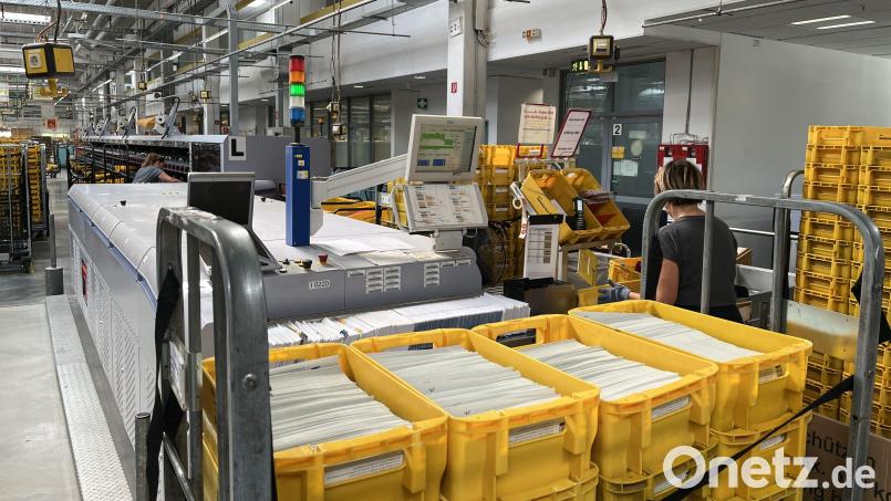 Eine Mitarbeiterin im Briefzentrum in Amberg sortiert die Wahlunterlagen. Bild: DHL Group/exb