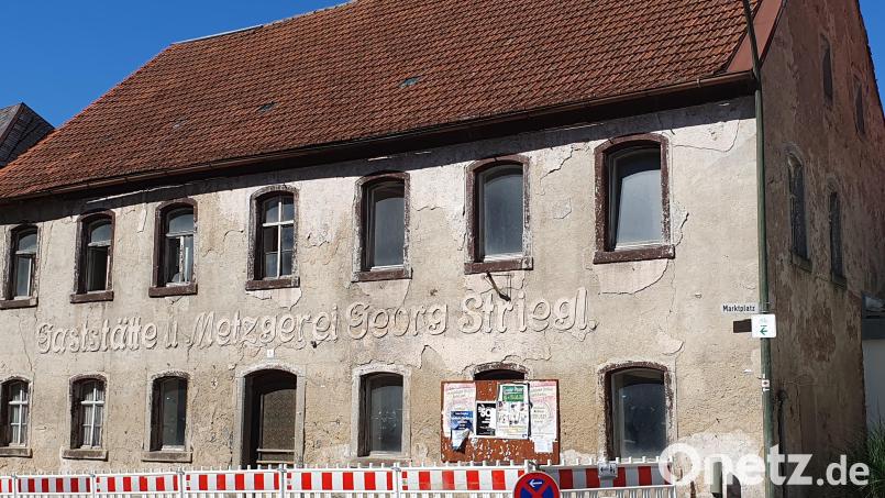 Der Gehweg vor dem maroden Gebäude am Marktplatz 4 in Waldthurn ist noch gesperrt. Vor zwei Wochen bröckelten hier aufgrund des starken Regens Gesteinsbrocken ab. Bild: Lowak