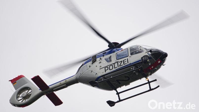 Ein Polizeihubschrauber fliegt bei einem Sucheinsatz über eine Stadt. Bild: Robert Michael/dpa-Zentralbild/ZB/Symbolbild