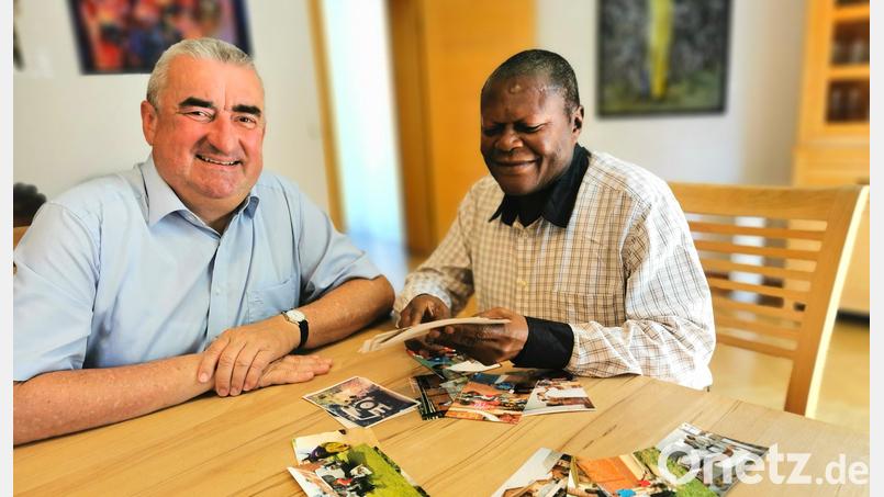 Pater André Kionga Jacques Phanzu zeigt Stadtpfarrer Alfons Kaufmann Fotos aus seiner Heimat im Kongo. Bild: Portner
