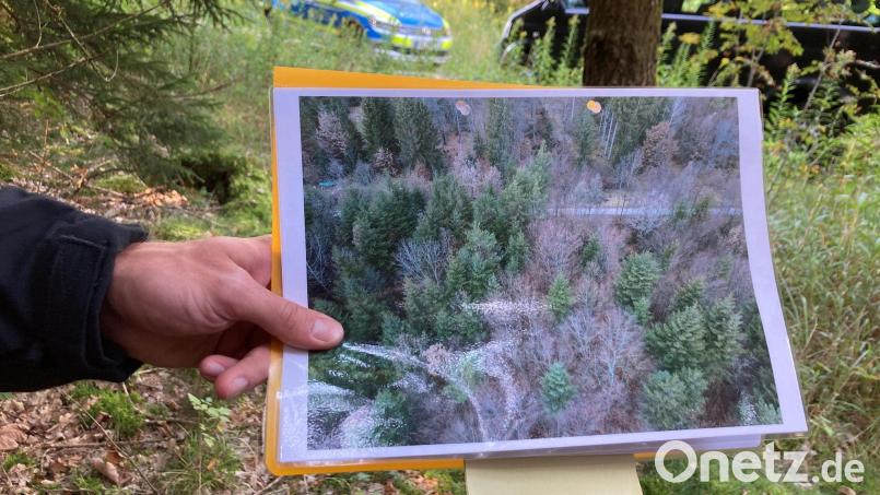 Ein Polizeibeamter hält ein Drohnen-Bild in der Hand. Bild: Sabine Dobel/dpa