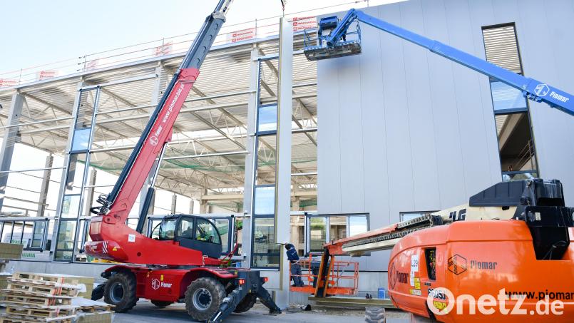 Derzeit wird die Außenfassade der 15 Meter hohen und über 2000 Quadratmeter großen Konfektionshalle angebracht. Digitalisierung und automatische Transportsysteme sollen die Produktion verschlanken und beschleunigen. Bild: Petra Hartl
