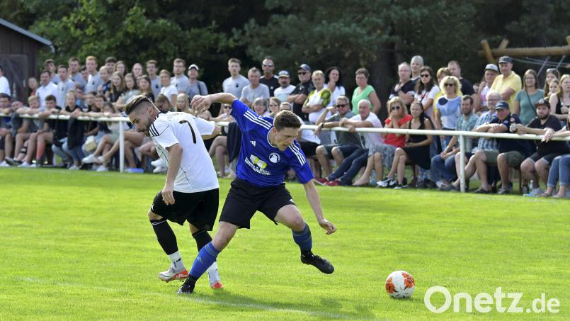 Vor prächtiger Zuschauerkulisse am Hahnenkamm: Neukirchens Spielertrainer Christian Ringler (links) im Zweikampf mit dem Edelsfelder Torschützen zum 2:2-Ausgleich, Patrick Dehling. Bild: Hubert Ziegler