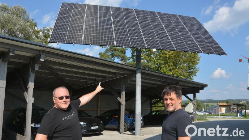 Seniorchef Jürgen Leiß (links) und der Bärnauer Günter Bauer zeigen auf den drehbaren „Tracker“, der sich nach der Sonne ausrichtet und so Strom erzeugt. Bild: jr