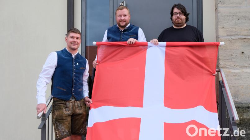 Am Wochenende wird die vom Kirwa-Verein gespendete Zachäusfahne am Turm von St. Laurentius wehen. Pfarrer Johannes Bosco nahm die neue Kirwafahne von Sebastian Wohlrab (Mitte) und Siegfried Zimmermann (links) in Empfang. Bild: do
