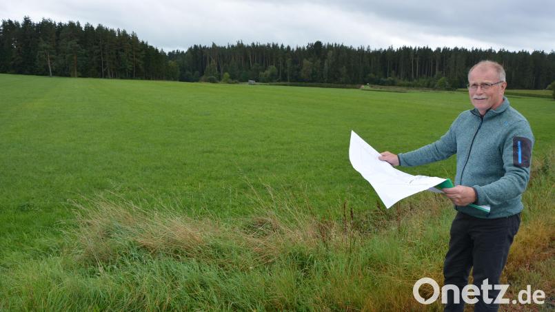 Bürgermeister Max Bindl verweist auf das rund ein Hektar große Grundstück (im Hintergrund), wo die neue Energiespeicheranlage entstehen soll. Baubeginn soll frühestens Ende 2025 sein. Bild: jr
