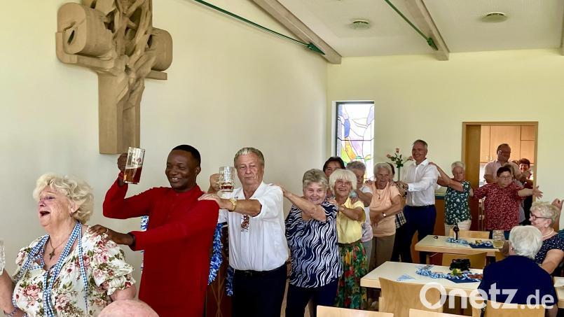 Angeführt von Bärbel Mohr und Pfarrer Francis Udechukwu Ozochi geht es in einer Polonaise durch den Saal. Bild: Krones/exb