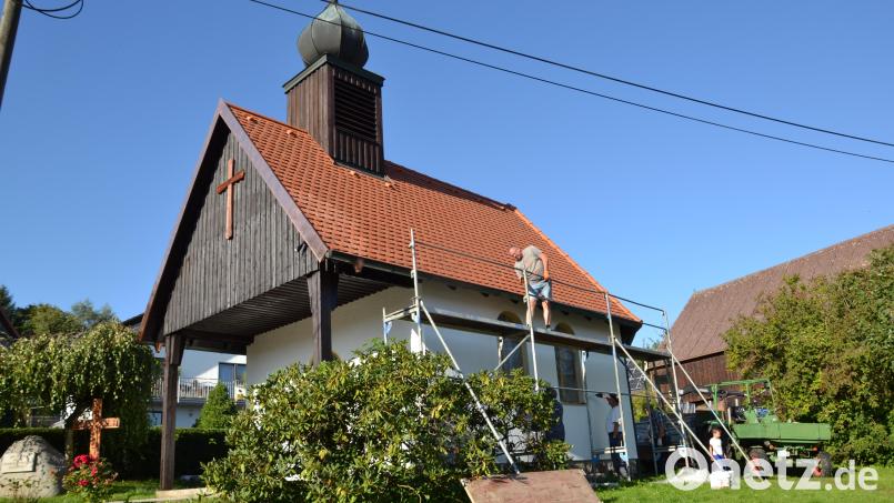 Nach der Dacherneuerung beseitigen die Rückersriether das Baugerüst an der Dorfkapelle. Bild: gi
