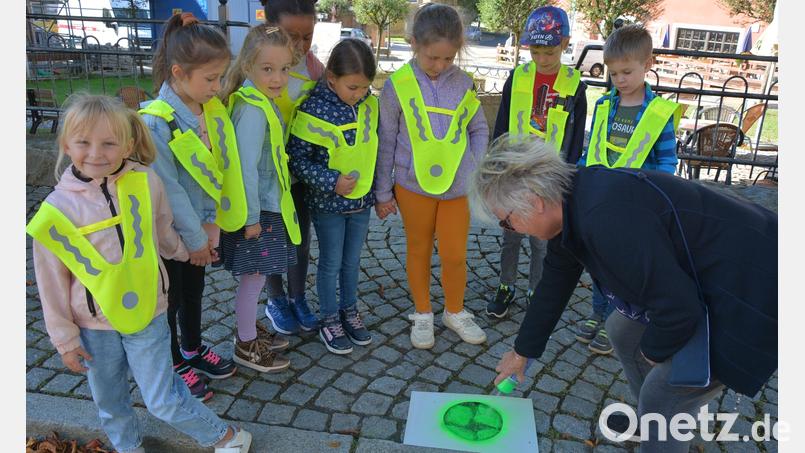 Pensionärin Doris Czerwik spritzt einen grünen Punkt auf einen Gehsteig im Ortskern von Konnersreuth, von wo aus eine sichere Überquerung der Straße und damit ein gefahrloser Weg zur Schule möglich ist. Bild: jr