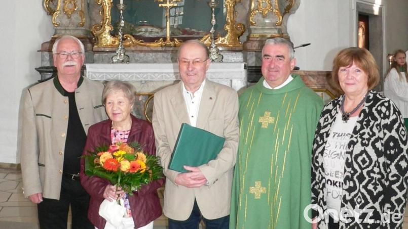 Kirchenpfleger Günter Flierl (im Bild links), Pfarrer Alfons Kaufmann (Vierter von links) und Pfarrgemeinderatssprecherin Renate Troppmann (rechts) würdigten die Verdienste von Paulinus Lesser, im Bild mit Ehefrau Maria. Bild: Niederalt/exb