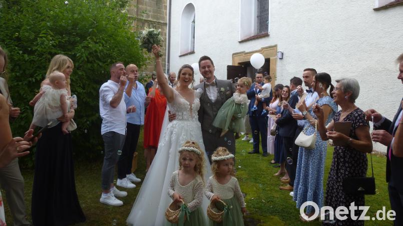 Strahlend durchschreiten Ronny und Janine Koppmann mit Töchterchen Leni, seit elf Monaten Mittelpunkt der Familie, das Spalier. Bild: bk