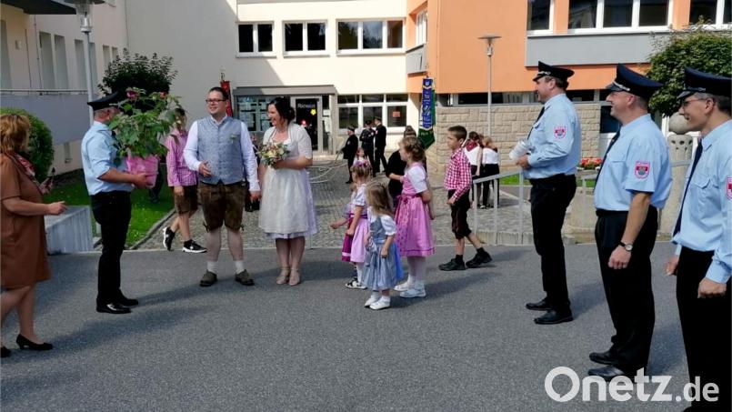 Der Vorsitzende der Feuerwehr Bergnetsreuth, Harald Kick, gratuliert Markus Riedel und Manuela Bruckner zur Hochzeit. Bild: Manfred Bock/exb